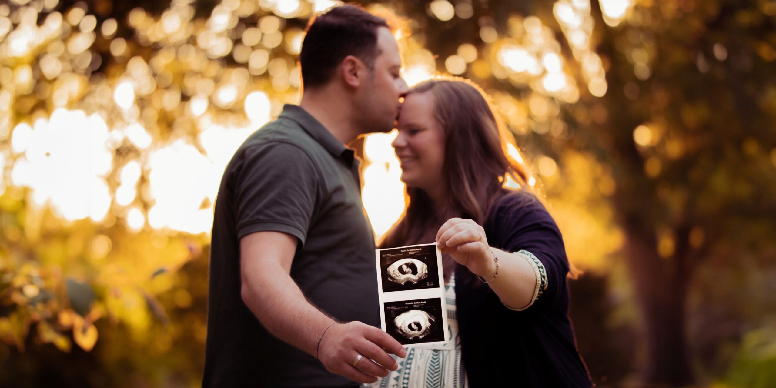 Man hält die Hand seiner schwangeren Frau und hat ein Ultraschallbild des Babys in der Hand - Hamid Afzali – Hochzeitsfotograf und Hochzeitsvideograf